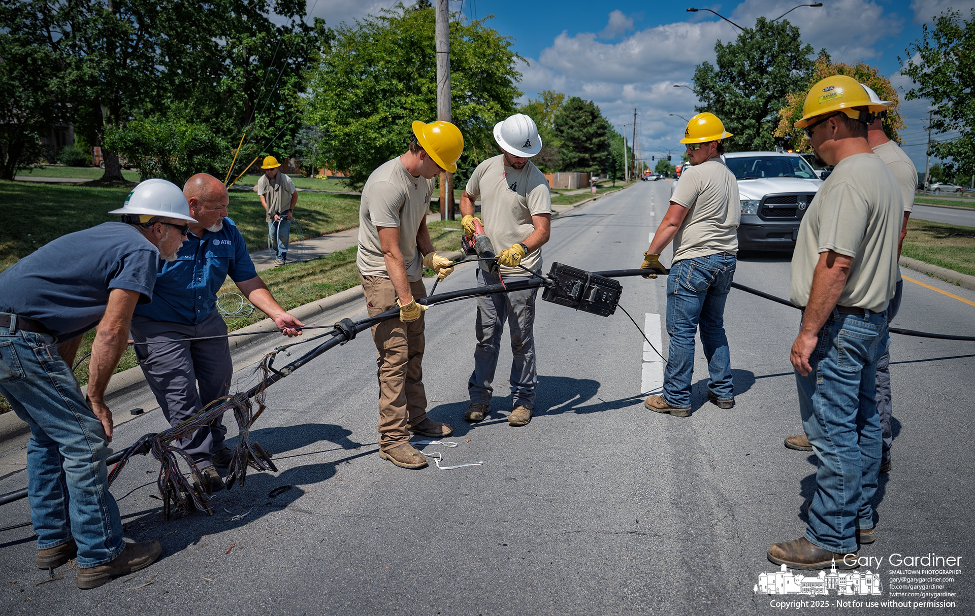Team holds the section steady for cutting.